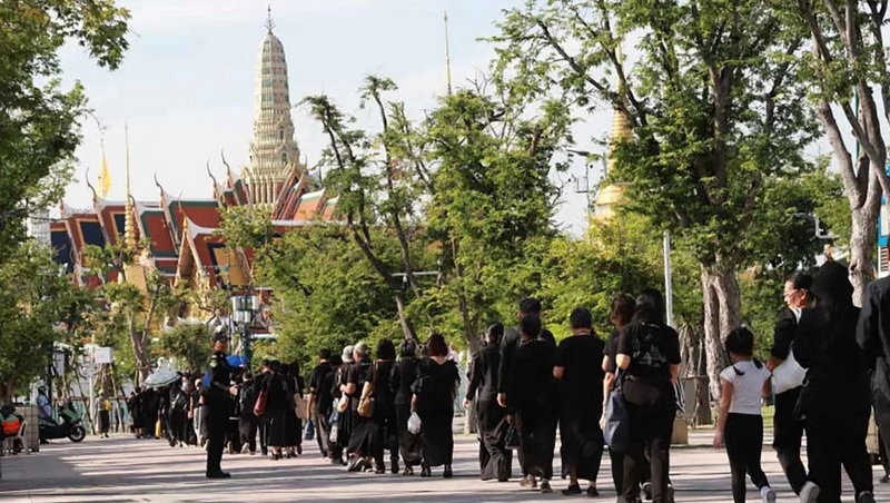 People walk from Sanam Luang to the Grand Palace to present water for the royal bathing ceremony for Her Majesty Queen Sirikit The Queen Mother yesterday morning (Oct 26). Photo: Apichart Jinakul